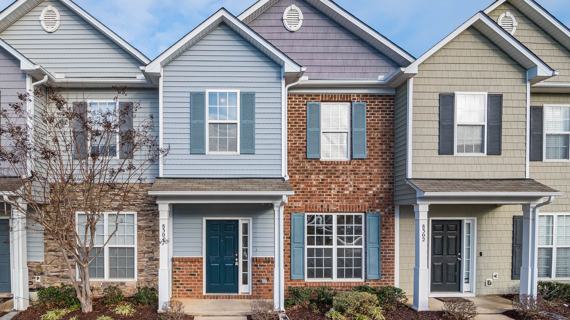 Row of townhouses with different siding colors and brick accents